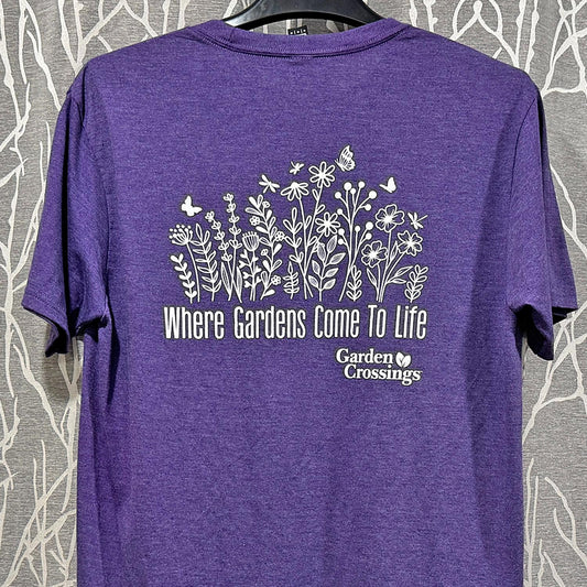 The Garden Crossings Tshirt is a purple soft tri-blend tee with white line drawings of flowers, butterflies, and bees above the text "Where Gardens Come To Life" and the Garden Crossings logo. Ideal for gardening t-shirt lovers!. -