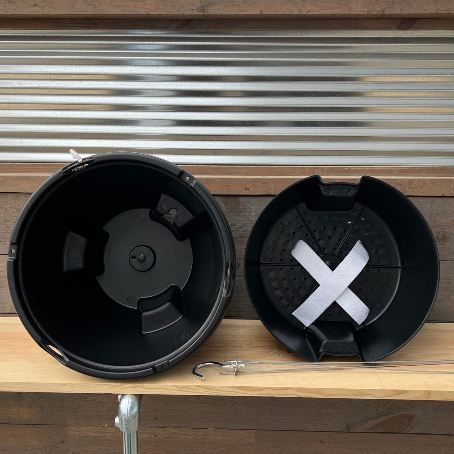 interior view of black hanging planter sitting sideways on a wooden table - Photo Property of Garden Crossings LLC.