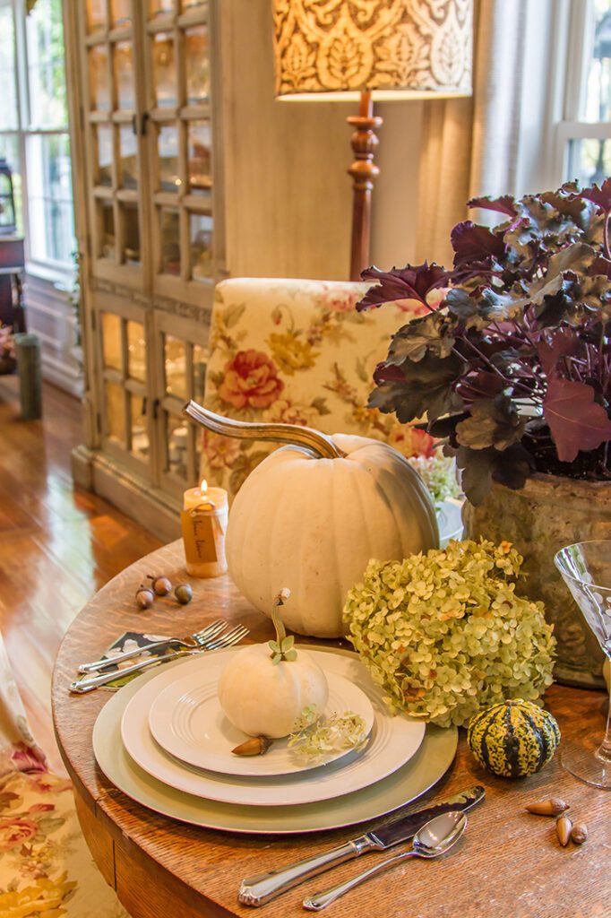 Thanksgiving themed table with dried hydrangea leaves and a potted heuchera