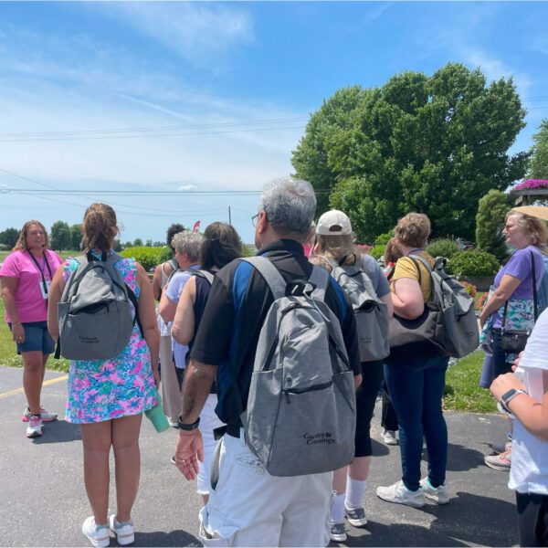 group of people with backbacks walking in a parkinglot