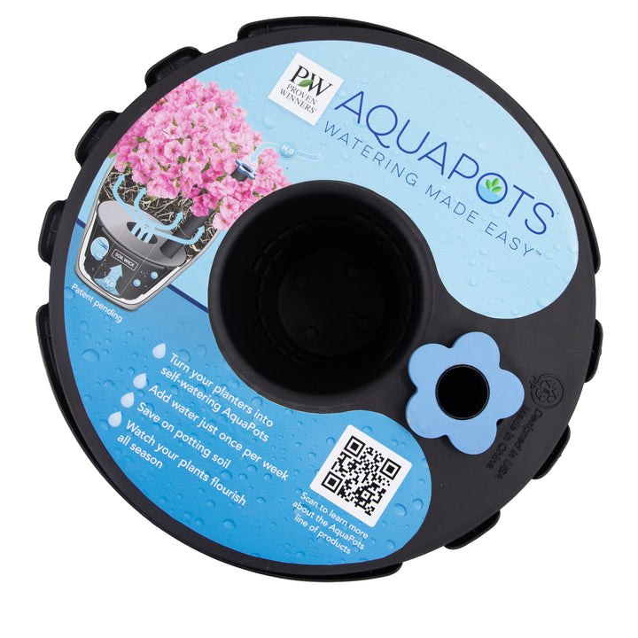 Round black AquaPots® Lite Insert lid features a blue and white Proven Winners label with pink flowers, product info, QR code, and self-watering instructions. A blue flower-shaped detail is near the edge.