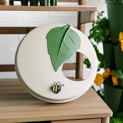 Decorative item with leaves and a bee on a wooden surface - 