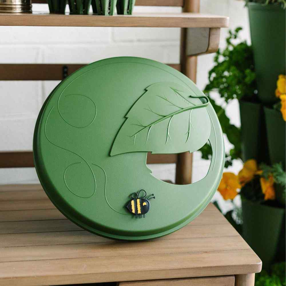 Green lid with leaf and bee design on a wooden surface - 
