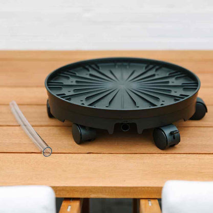 circular black base with wheels sitting on wooden table - 