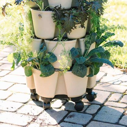 Stacked beige pots with plants on a stone patio - 